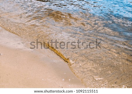 Beach sand with blue water.