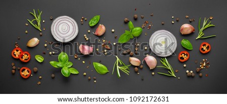 various herbs and spices on black background, top view