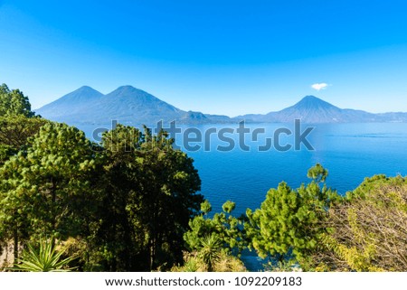 View from Lake Atitlan in the early morning, blue skys and clear water, beautiful magic lake with volcanos and indigenous people in the highland of Guatemala