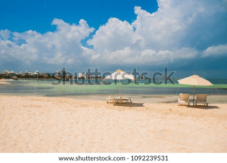 Sun loungers and umbrellas for tourists on the beach in Cancun, Mexico. Royalty-Free Stock Photo #1092239531