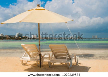Sun loungers and umbrellas for tourists on the beach in Cancun, Mexico. Royalty-Free Stock Photo #1092239534