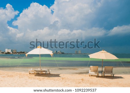 Sun loungers and umbrellas for tourists on the beach in Cancun, Mexico. Royalty-Free Stock Photo #1092239537