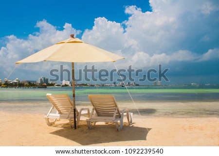 Sun loungers and umbrellas for tourists on the beach in Cancun, Mexico. Royalty-Free Stock Photo #1092239540