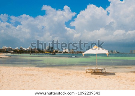 Sun loungers and umbrellas for tourists on the beach in Cancun, Mexico. Royalty-Free Stock Photo #1092239543