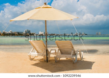 Sun loungers and umbrellas for tourists on the beach in Cancun, Mexico. Royalty-Free Stock Photo #1092239546