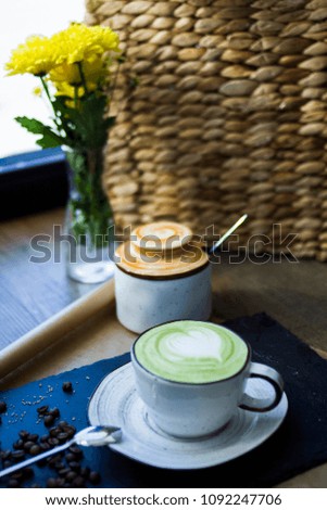 A cup with a beautiful green coffee on the restaurant table, in the background a sugar bowl