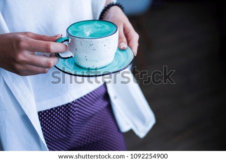 Cup with coffee in female hands background