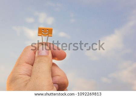 Colorful clip on man's hand in to sky background