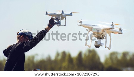 quadcopter in flight and in hand with shallow depth of field