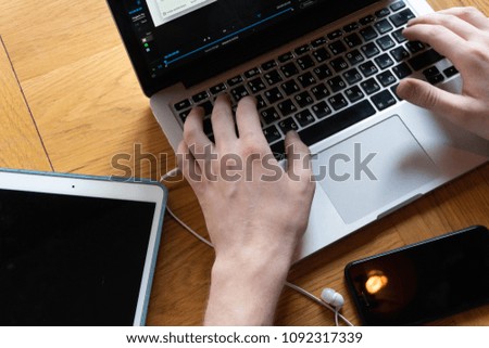picture of hands, laptop, cellphone and a tablet