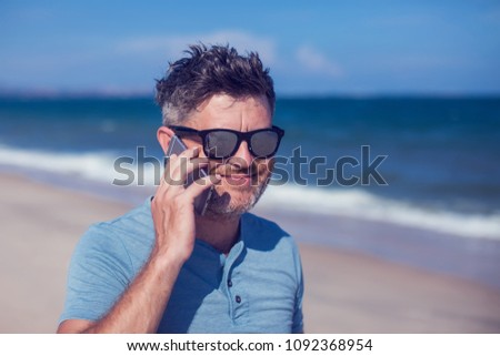 Young man using smartphone on the beach