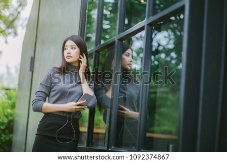 Girl standing listening to music.