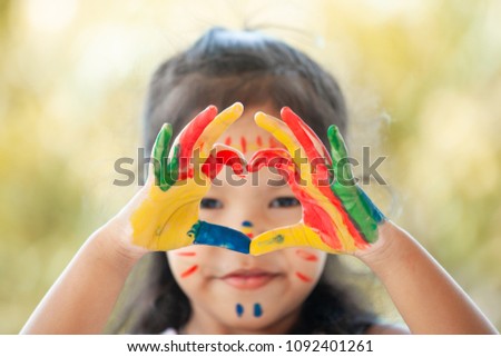 Child's hand with painted colorful watercolor make heart shape