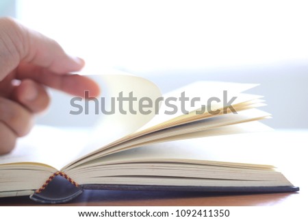 Close-up of fingers opening a book to read selective focus and shallow depth of field 