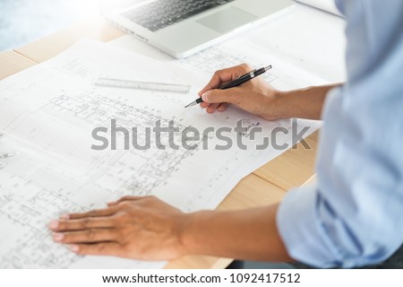 Person's engineer Hand Drawing Plan On Blue Print with architect equipment, Architects working at the table Royalty-Free Stock Photo #1092417512