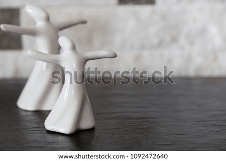  isolated porcelain figurines of mevlana on black background . ramadan concept. symbol of love and tolerance