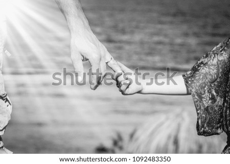 Beautiful hands of parent and child on sea background