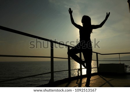 the silhouette of the woman are dancing aboard the sunset background