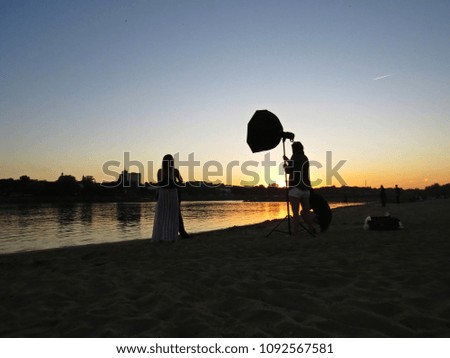 Professional Photographer Photo Session with Just Married Newly-Wed Couple on a Beach during Sunset