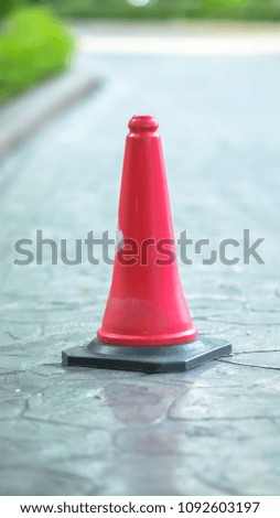 Traffic cone on road. Red traffic cone standing outside. Traffic cone at parking area