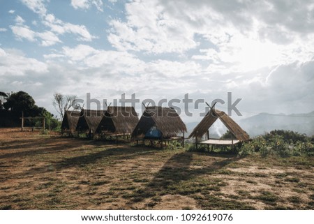 The blank wooden litter with dry leaves roof and blue sky, mountain and tree foreground in winter of thailand. tourist  rent this litter for place camping tent.