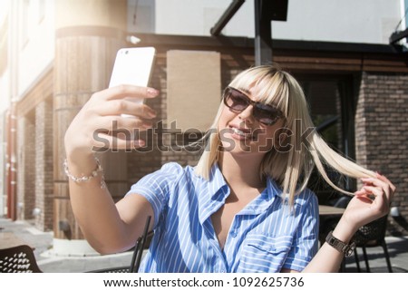 blonde attractive girl taking selfie in coffee shop 