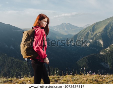 A traveler in a pink jacket and with a backpack on her back