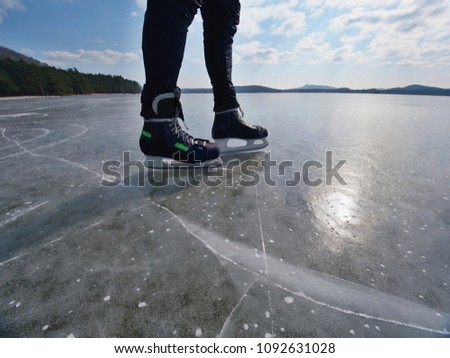 Ice skating. An athlete man stay with hockey ice skates on an frozen lake, winter concept