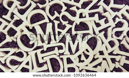 random white wooden alphabet letters top view on purple background
