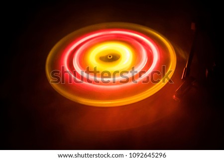Music concept. Freezelight glowing vinyl on dark background or Turntable playing vinyl with glowing abstract lines concept on dark background. For Club poster Design