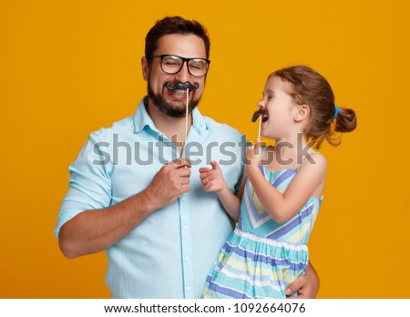 happy father's day! funny dad and daughter with mustache fooling around on colored yellow background
 Royalty-Free Stock Photo #1092664076