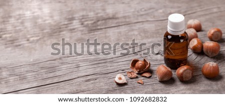 Oil from hazelnut, nutritious elements. Bottle of oil and nuts on an old wooden table. Copy space for text