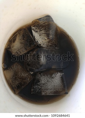 Sparkling water Cola with straw and ice ready to drink for refreshment.
