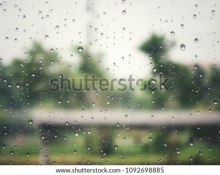 Droplet water on glass of windows with blurred nature background