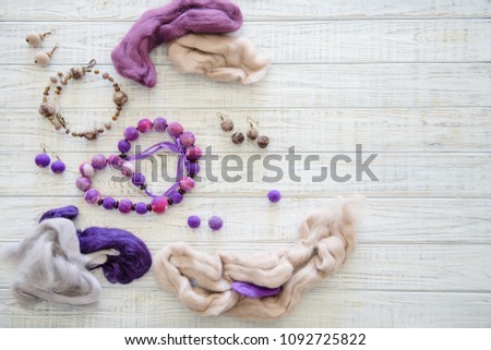 Flat lay of wet felting beads, earrings and colorful yarn. Handcraft concept, top view 