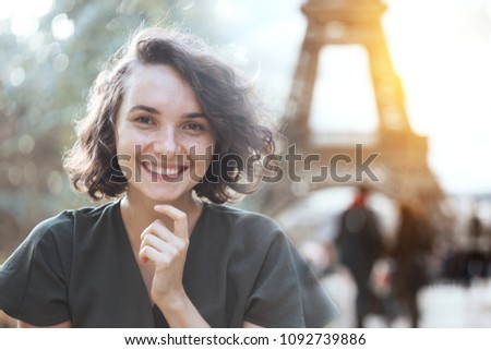 portrait of a happy smiling girl against the background of the Eiffel Towerin Paris. France 
