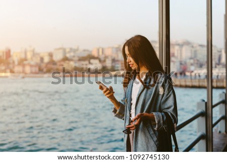 Girl with a phone on the shoreline. Istanbul, Turkey