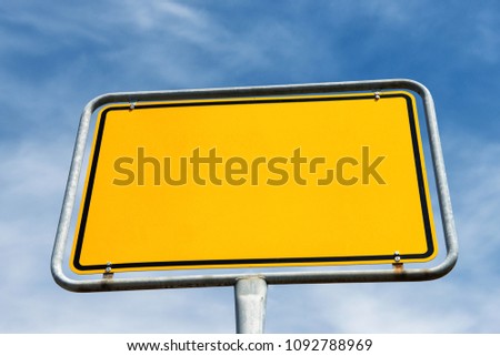 Blank yellow city sign in Germany. Template with copy space isolated on blue sky and clouds.