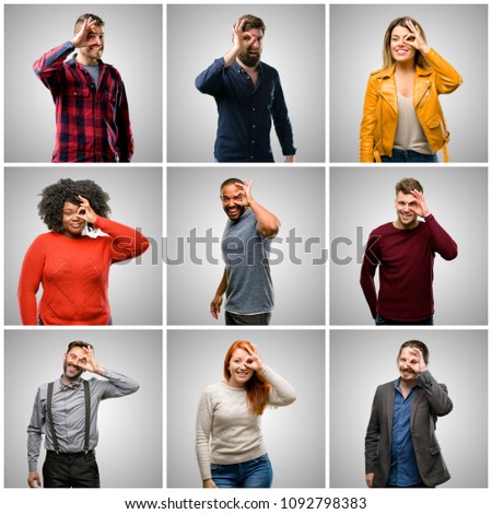 Group of mixed people, women and men looking at camera through fingers in ok gesture. Imitating binoculars, beautiful eyes and smile
