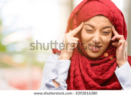 Young arab woman wearing hijab doubt expression, confuse and wonder concept, uncertain future