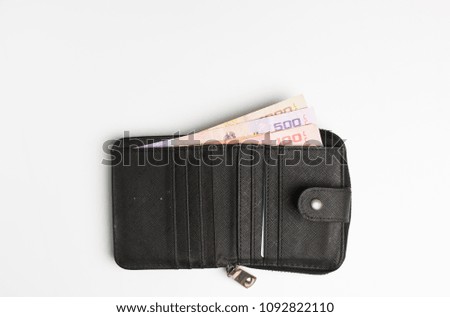 Money in black wallet on white background,selective focus.