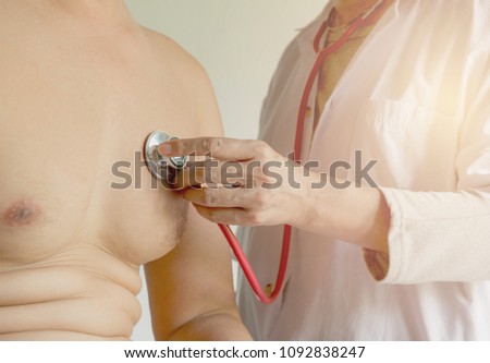 Female doctor using stethoscope for check and listen to heart and lungs of patient at a hospital.