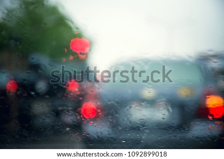 Drops water on a car windshield with Blurry car background at rainy day in the city