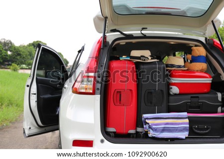Closeup of rear side of white car carries luggages, suitcases and other things preparing for lovely family holiday in summer with natural background. Royalty-Free Stock Photo #1092900620