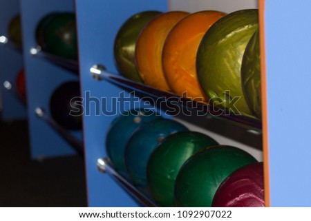 Multicolored bowling balls of different weight ready for the game
