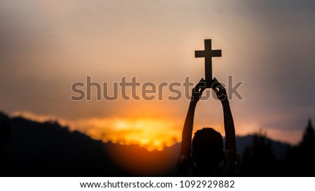 hands off children holding christian cross with light sunset background,christian concept.