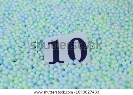 The number 10 of the piece of paper in a pile of small spheres