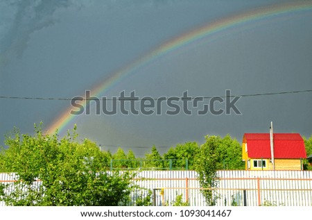rainbow in the storm sky, rural area in Russia