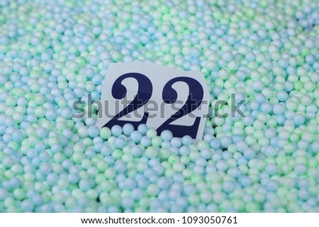The number 22 of the piece of paper in a pile of small spheres