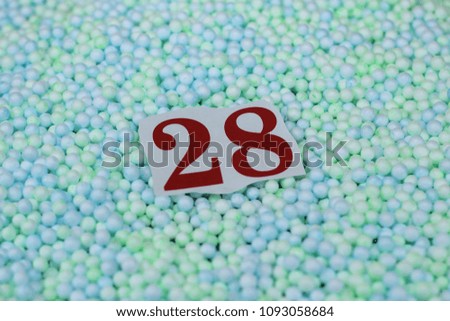 The number 28 of the piece of paper in a pile of small spheres